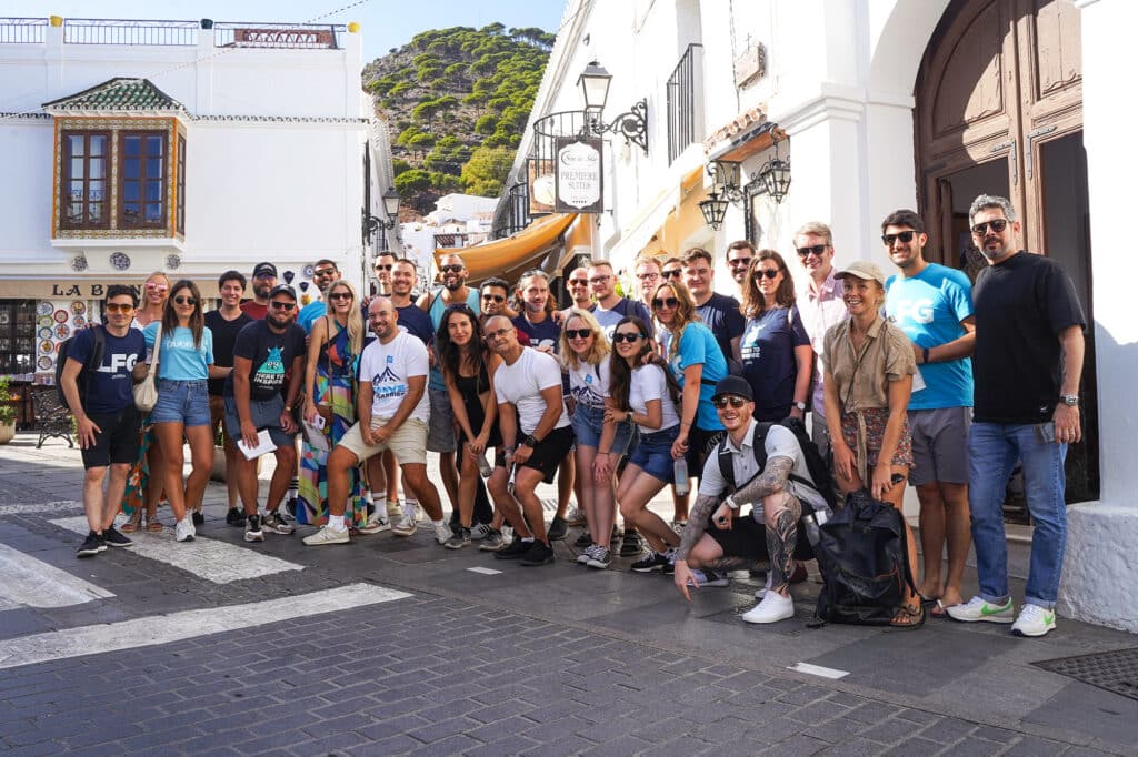 Custom Catalog Solutions 2 A large group photo of Publitas employees smiling while visiting Mijas in Spain. Sunny weather.