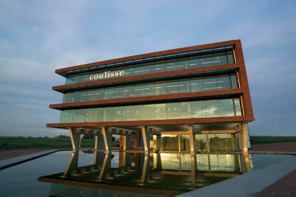 Coulisse — Crafting Interactive Experiences for Customers 5 Coulisse's headquarters. A modern-looking 4-story building reflected in the water.