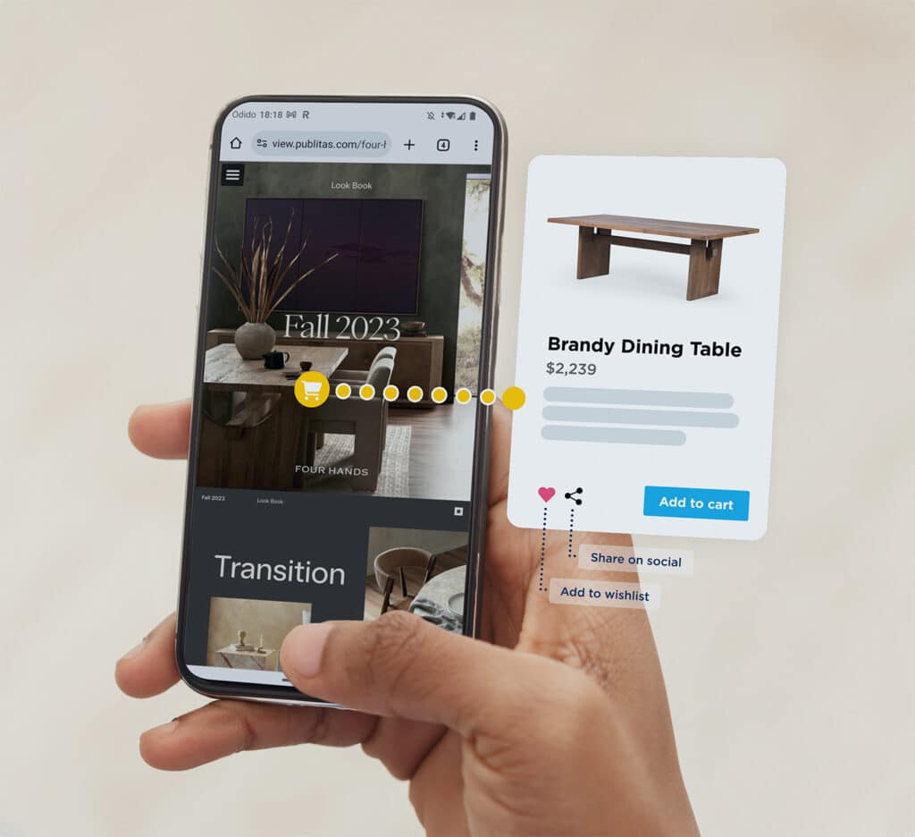 Digital Catalog 1 Close up of a mobile phone held in hand. The display shows a home decor catalog and a product page for a Brandy Dining Table (with add to cart button).